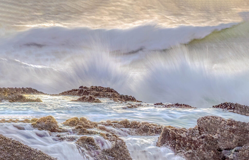 a beautiful coastline with waves crashing against brown rocks